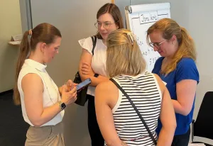 Vier Teilnehmerinnen tauschen ihre Kontakte aus.