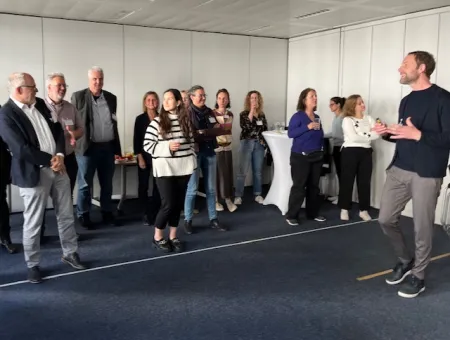 Dr. Oliver Borszik leitet Teilnehmende an, die hinter einer Linie stehen.