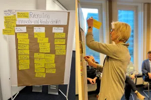 Ute Flügge heftet Karten an eine Metaplanwand.